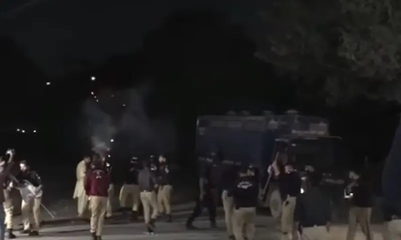 Police personnel fire tear gas to disperse protesters near the Sindh Assembly on February 14. &mdash; DawnNewsTV