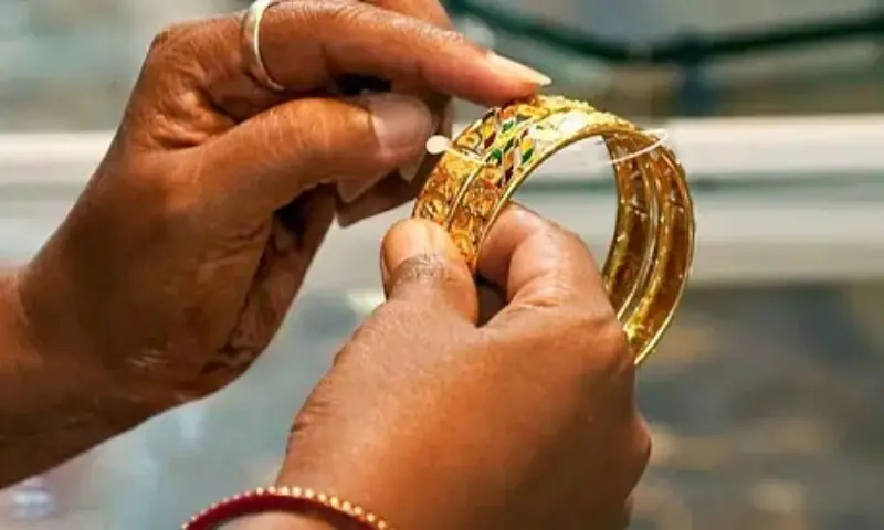 This file photo shows a person holding gold bangles. &mdash; AFP/File