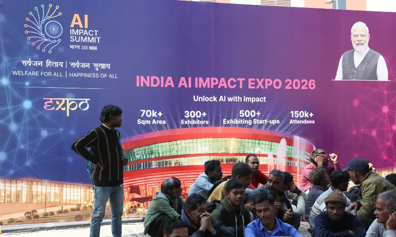 Workers sit in front of a banner of India AI Impact Summit at Bharat Mandapam in New Delhi, India on Febr 16, 2026. — Reuters Workers sit in front of a banner of India AI Impact Summit at Bharat Mandapam in New Delhi, India on Febr 16, 2026. — Reuters