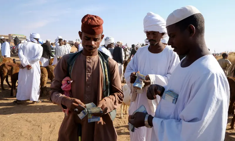 Livestock traders count money after completing a sale at the livestock export market, in El Obeid, North Kordofan State, Sudan on January 17, 2026. &mdash; Reuters