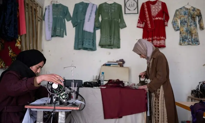 his photograph taken on January 20, 2026 shows Afghan tailoress Rahima Alavi (L) embroidering scarves and clothes at her boutique in Bamiyan. &mdash;AFP