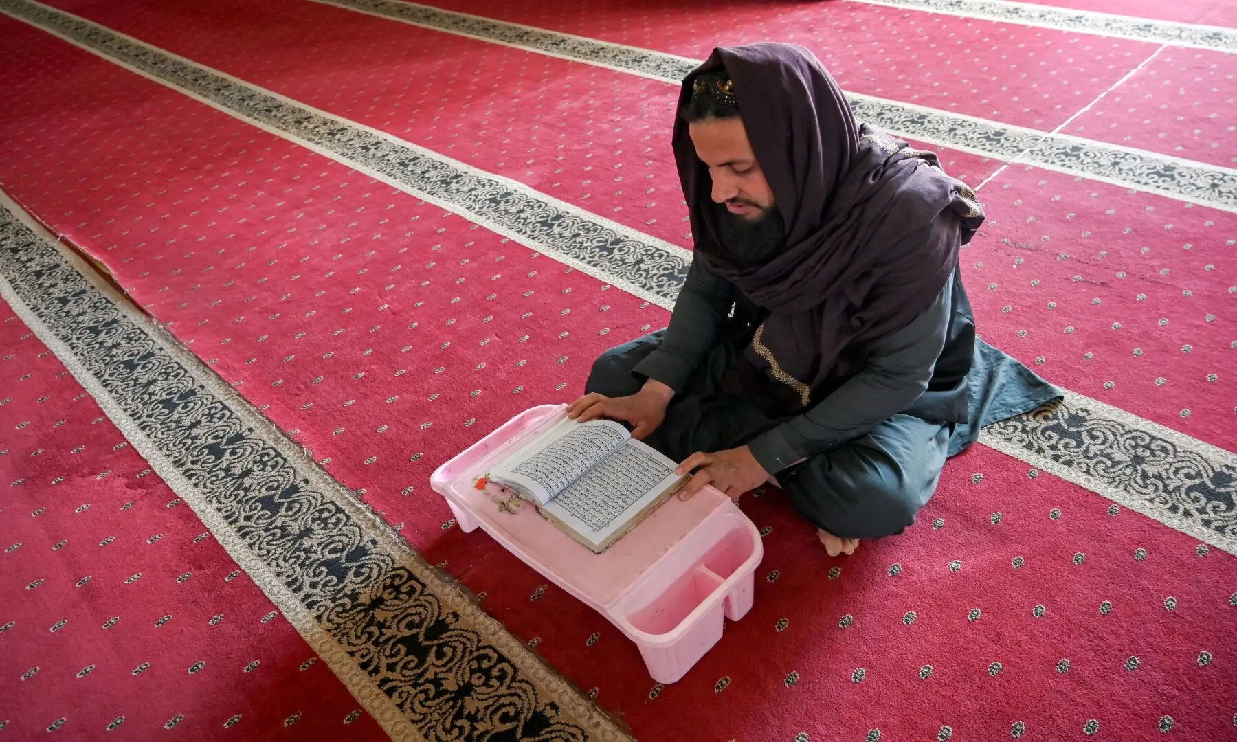 A madrassa student recites the Quran on the first day of Ramazan, in Peshawar on February 19, 2026. &mdash; Abdul Majeed/ AFP