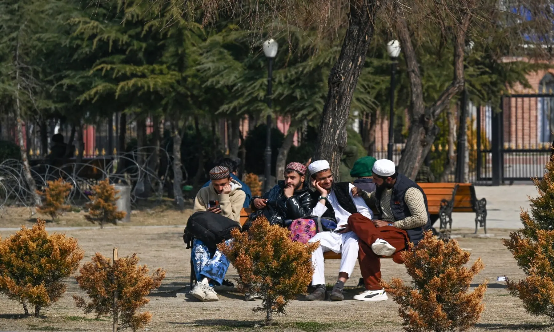 Men sit on a bench in a park on the first day of Ramazan, in Indian-occupied Kashmir on February 19, 2026. &mdash; Tauseef Mustafa/ AFP
