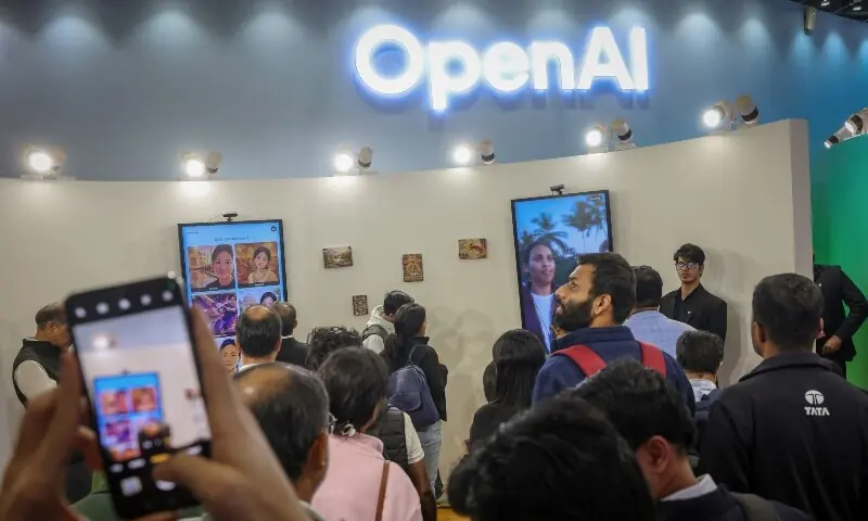 Visitors wait in queue at the OpenAI kiosk to receive an AI-generated printed image at the AI Impact Summit, in New Delhi, India, February 20. &mdash; Reuters