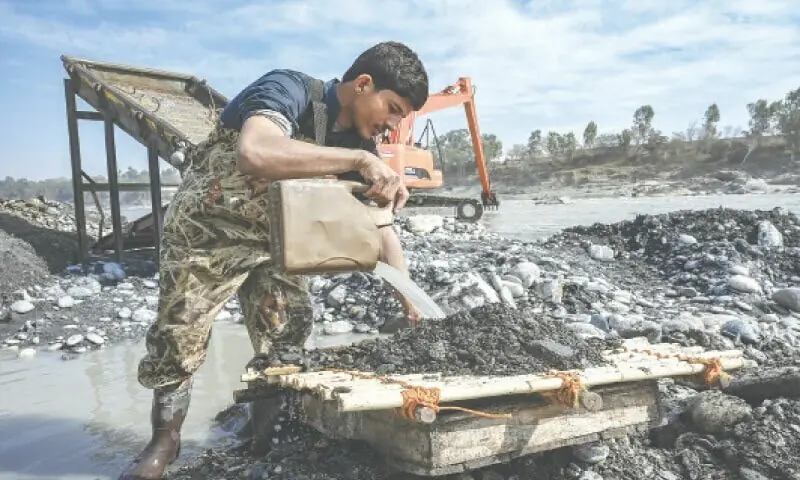 A miner looks for precious metal in river sediment, in the Kund area of Nowshera district.&mdash;Abdul Majeed Goraya/File