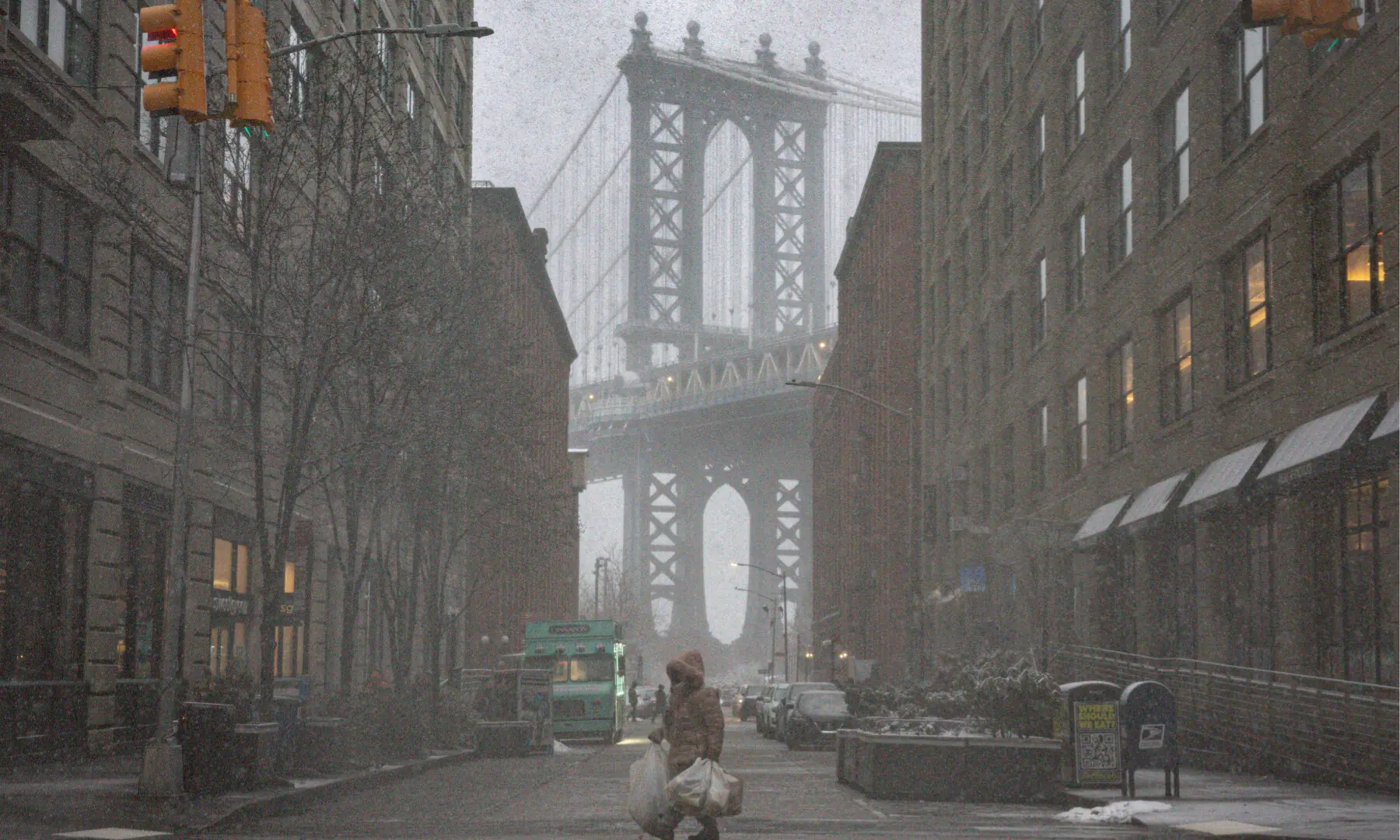 A pedestrian walks on a street as snow falls during a winter storm in the Brooklyn Borough of New York City, US on Feb 22, 2026. &mdash; Reuters