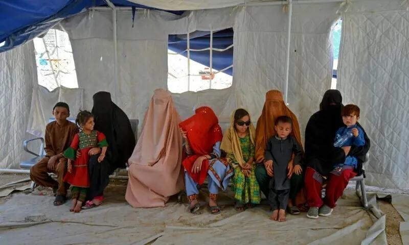 Afghans sit inside a tent after their arrival from Pakistan, in Takhta Pul, Afghanistan on June 4.  &mdash; AFP