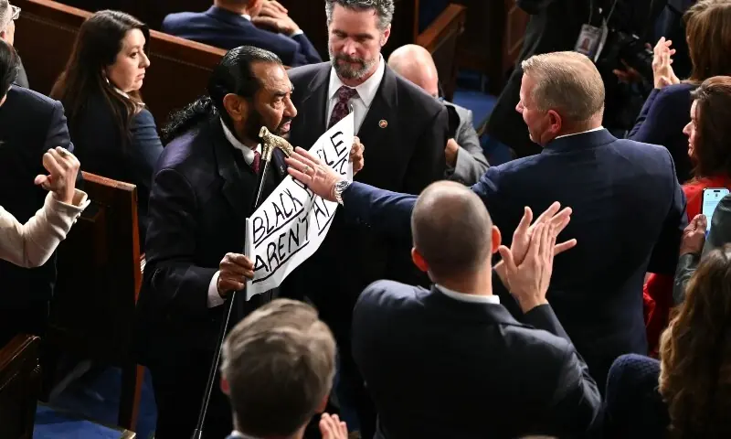 US Representative Al Green, Democratic from Texas, exits as he holds a sign reading &ldquo;Black people aren&rsquo;t apes&rdquo; as US President Donald Trump delivers the State of the Union address in the House Chamber of the US Capitol in Washington, DC, on February 24, 2026. &mdash;AFP