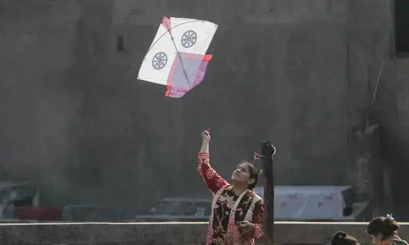 A woman flies a kite from a rooftop to mark Basant, a kite-flying festival, in Lahore, February 6. — Reuters A woman flies a kite from a rooftop to mark Basant, a kite-flying festival, in Lahore, February 6. — Reuters