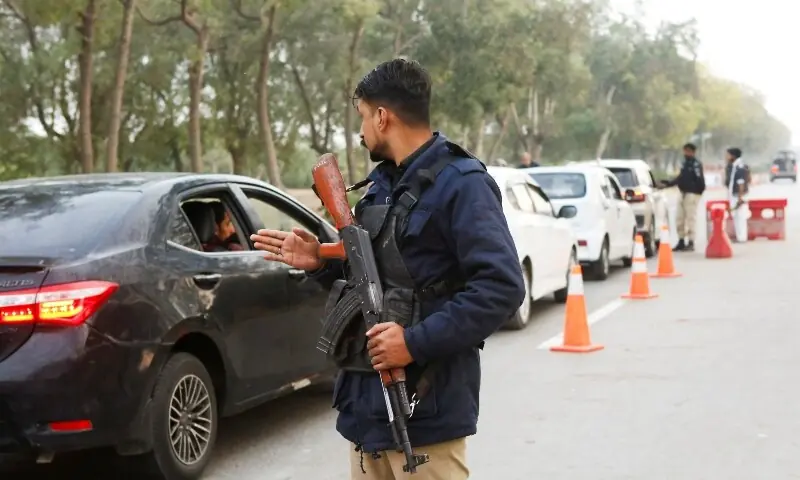 A police officer controls traffic flow as a security measure along a road leading to the airport in Karachi, Pakistan on February 28, 2026. &mdash; Reuters