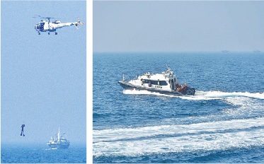 A helicopter is used to airlift a crew member of a stranded boat from a raft; a PMSA boat (right) in action during the maritime exercise Sea Guard.&mdash;Fahim Siddiqi / White Star