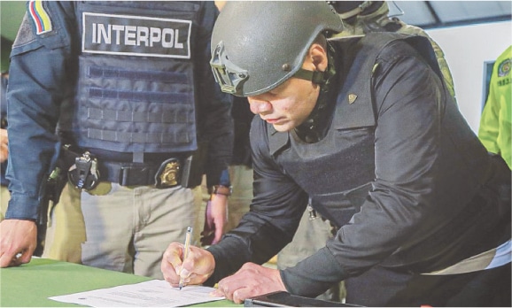  Pipe Tulua signs a document before his extradition to the US.&mdash;AFP 
