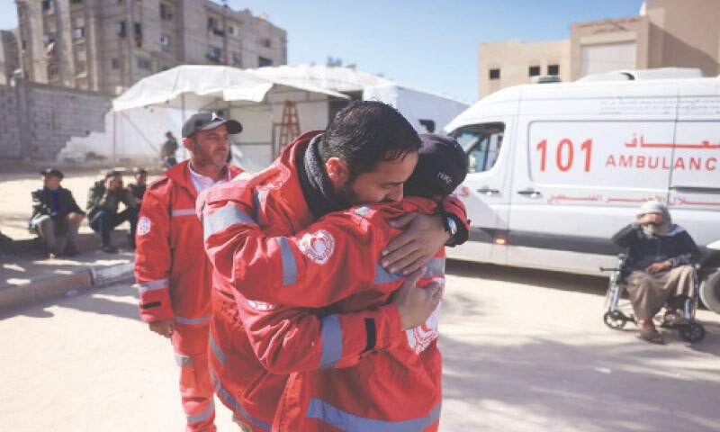 MEMBERS of the Palestinian Red Crescent comfort one another during the funeral of a colleague who was killed in an Israeli strike on a camp housing displaced Palestinians in Khan Yunis.&mdash;AFP