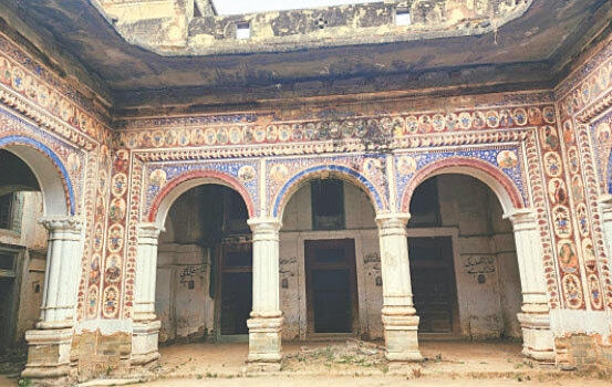 The fading picturesque fresco work seen on the arches of the inner verandas.