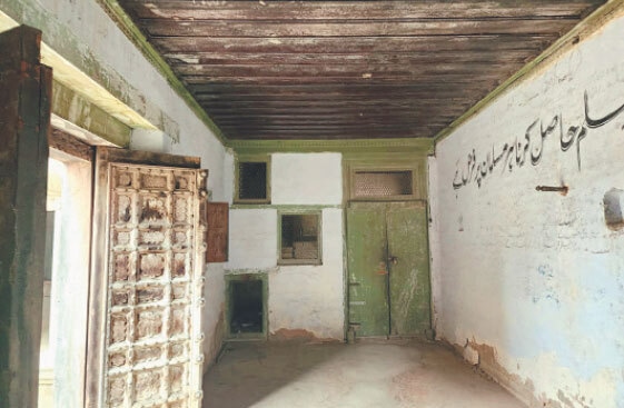 one of the big rooms with a heavy wooden door and red brown planks on the roof.