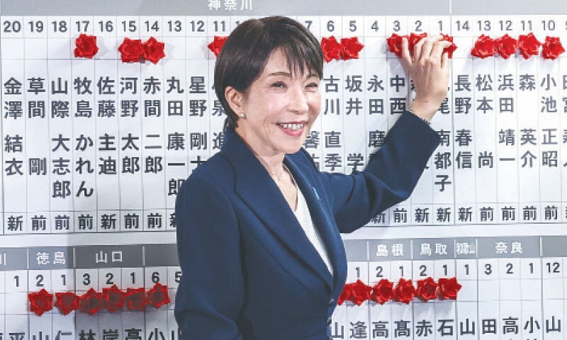 JAPAN&rsquo;S PM Sanae Takaichi places a red paper rose on the elected candidate&rsquo;s name at the LDP headquarters during the House of Representatives election.&mdash;AFP