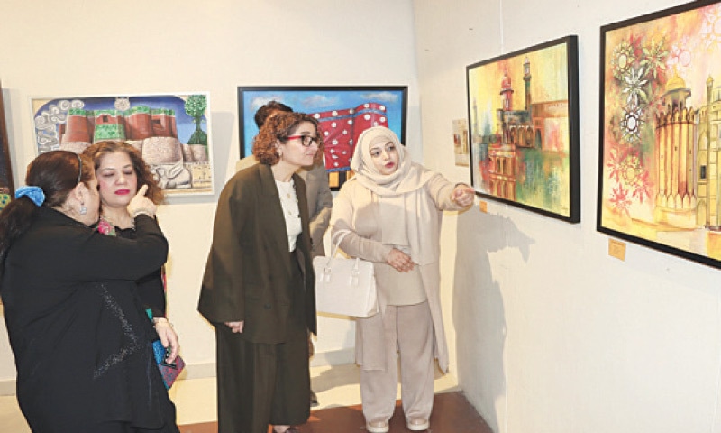 An artist explains her painting to Turkish Republic of Northern Cyprus representative Buket Kop during an exhibition at the Rawalpindi Arts Council on Monday. &mdash; White Star