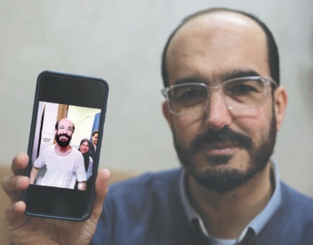 Samer Khaweireh shows a photo of how he appeared the day he was released from prison after he lost 22 kilos in nine months.—Reuters