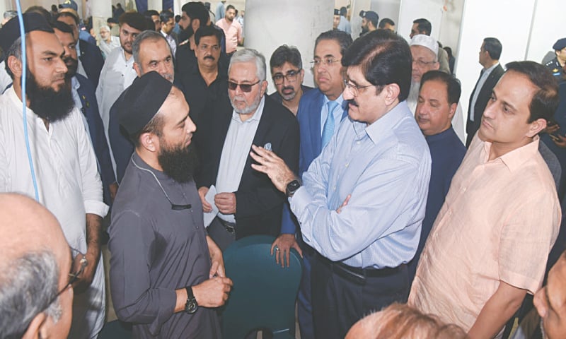 Chief Minister Syed Murad Ali Shah interacts with a trader as Zubair Motiwala and Karachi Mayor Murtaza Wahab look on.—Dawn Chief Minister Syed Murad Ali Shah interacts with a trader as Zubair Motiwala and Karachi Mayor Murtaza Wahab look on.—Dawn