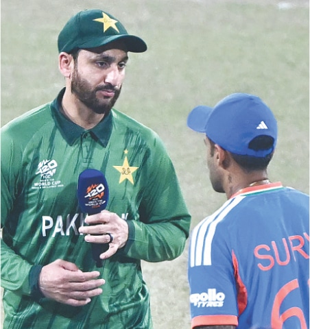 PAKISTAN captain Salman Ali Agha (L) walks past his Indian counterpart Suryakumar Yadav after the toss on Sunday.—AFP