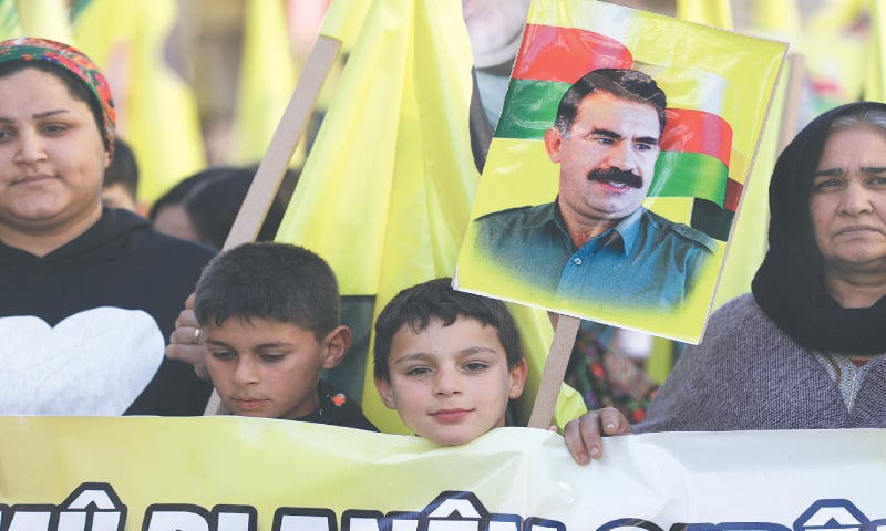Qamishli (Syria): A child holds a portrait of PKK leader Abdullah Ocalan during a demonstration by Syrian Kurds for his release from prison. Ocalan is jailed in Turkiye since his capture in 1999.&mdash;Reuters