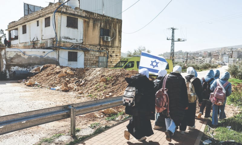 SCHOOLCHILDREN walk past an Israeli dirt barrier between Nablus and Ramallah, in the occupied West Bank.—Reuters SCHOOLCHILDREN walk past an Israeli dirt barrier between Nablus and Ramallah, in the occupied West Bank.—Reuters