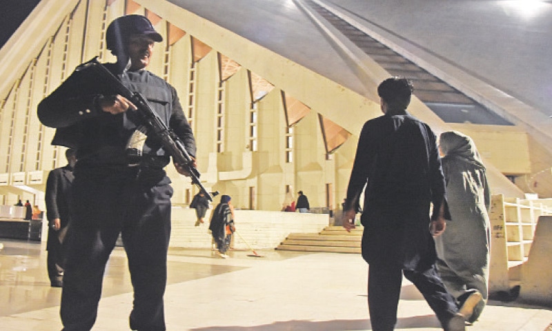 A policeman stands alert and people arrive at Faisal Mosque in Islamabad to offer Taraweeh prayers on Wednesday. &mdash; Online