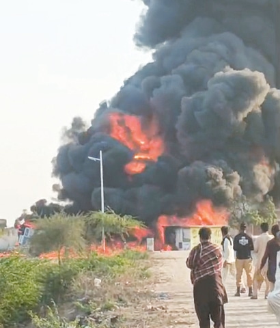 AN overturned oil tanker burns on Hyderabad-Thatta road, sending plumes of black smoke into the air.— Umair Ali