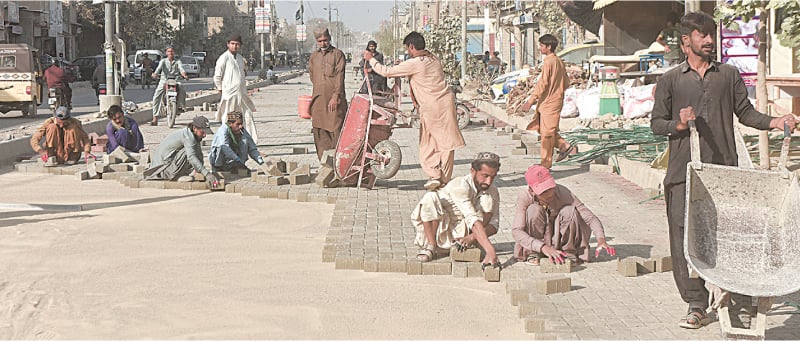 Workers fix paver blocks on one track of Jahangir Road. The paver tiles are used for construction of driveways, footpaths, courtyards and other outdoor areas and experts say these aren&rsquo;t meant to handle regular traffic. However, officials say frequent sewerage issues on one of the city&rsquo;s major roads led to the decision to opt for paver blocks over traditional asphalt for reconstruction.&mdash;Fahim Siddiqi / White Star