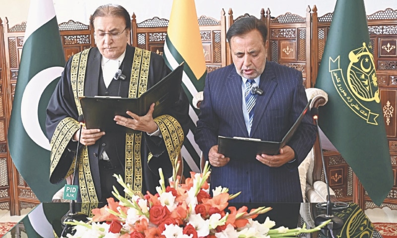 MUZAFFARABAD: AJK Chief Justice Raja Saeed Akram (left) administers oath to retired Justice Ghulam Mustafa Mughal as the region’s Chief Election Commissioner for a five-year term on Friday.—Photo by the writer MUZAFFARABAD: AJK Chief Justice Raja Saeed Akram (left) administers oath to retired Justice Ghulam Mustafa Mughal as the region’s Chief Election Commissioner for a five-year term on Friday.—Photo by the writer
