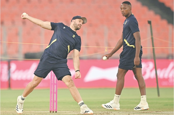 South African captain Aiden Markram bowls as team-mate Kagiso Rabada looks on during a training session at the Narendra Modi Stadium on Saturday.—AFP