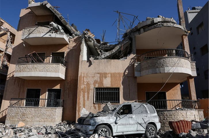 A destroyed vehicle lies outside a damaged building in the aftermath of an Israeli strike in Lebanon’s Bekaa valley.—Reuters