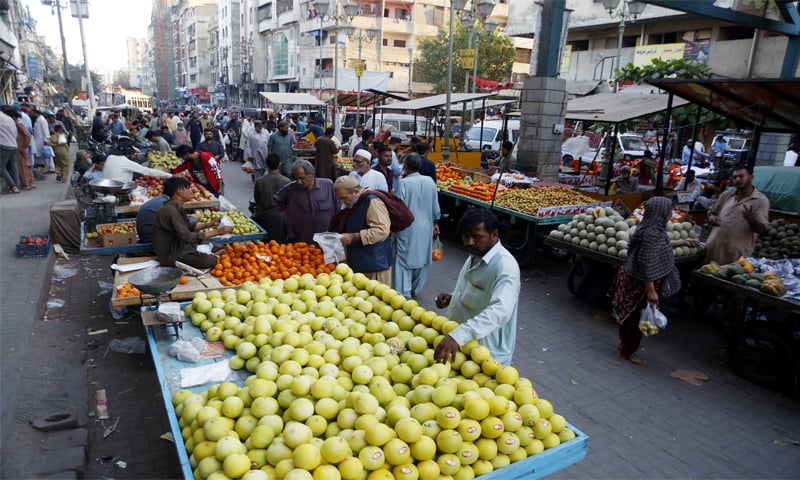 People buy fruit from roadside vendors in Malir.—Shakil Adil / White Star People buy fruit from roadside vendors in Malir.—Shakil Adil / White Star