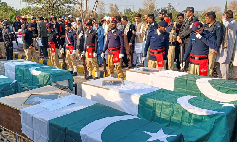 POLICE officers and residents gather beside flag-draped coffins of the martyred police personnel before the funeral in Kohat.—Reuters POLICE officers and residents gather beside flag-draped coffins of the martyred police personnel before the funeral in Kohat.—Reuters