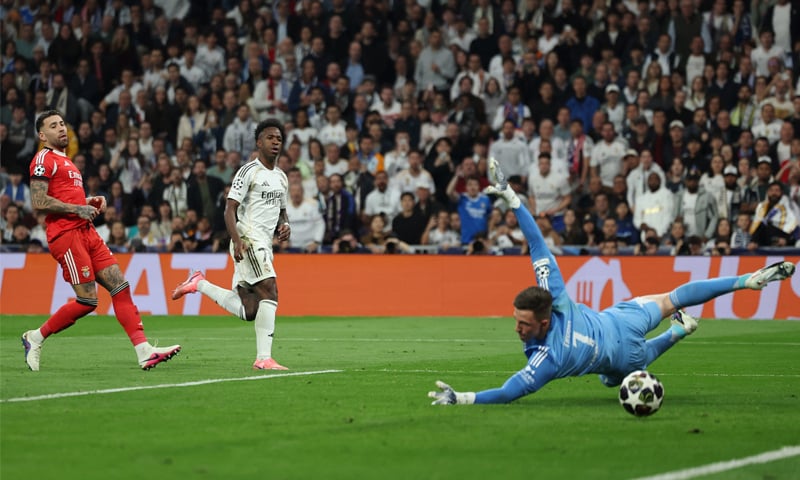 MADRID: Real Madrid’s Vinicius Junior (C) scores past Benfica goalkeeper Anatoliy Trubin during their Champions League play-off second leg at Santiago Bernabeu.—Reuters MADRID: Real Madrid’s Vinicius Junior (C) scores past Benfica goalkeeper Anatoliy Trubin during their Champions League play-off second leg at Santiago Bernabeu.—Reuters