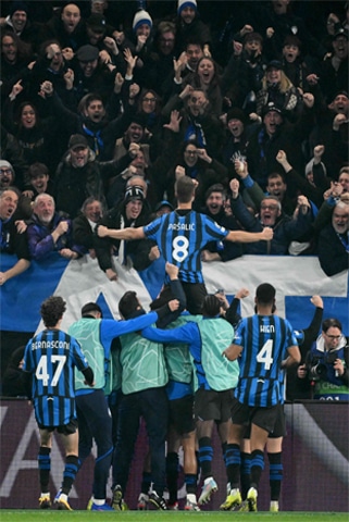 BERGAMO: Atalanta’s Mario Pasalic (top) celebrates with supporters and team-mates after scoring against Borussia Dortmund at Stadio di Bergamo.—AFP
