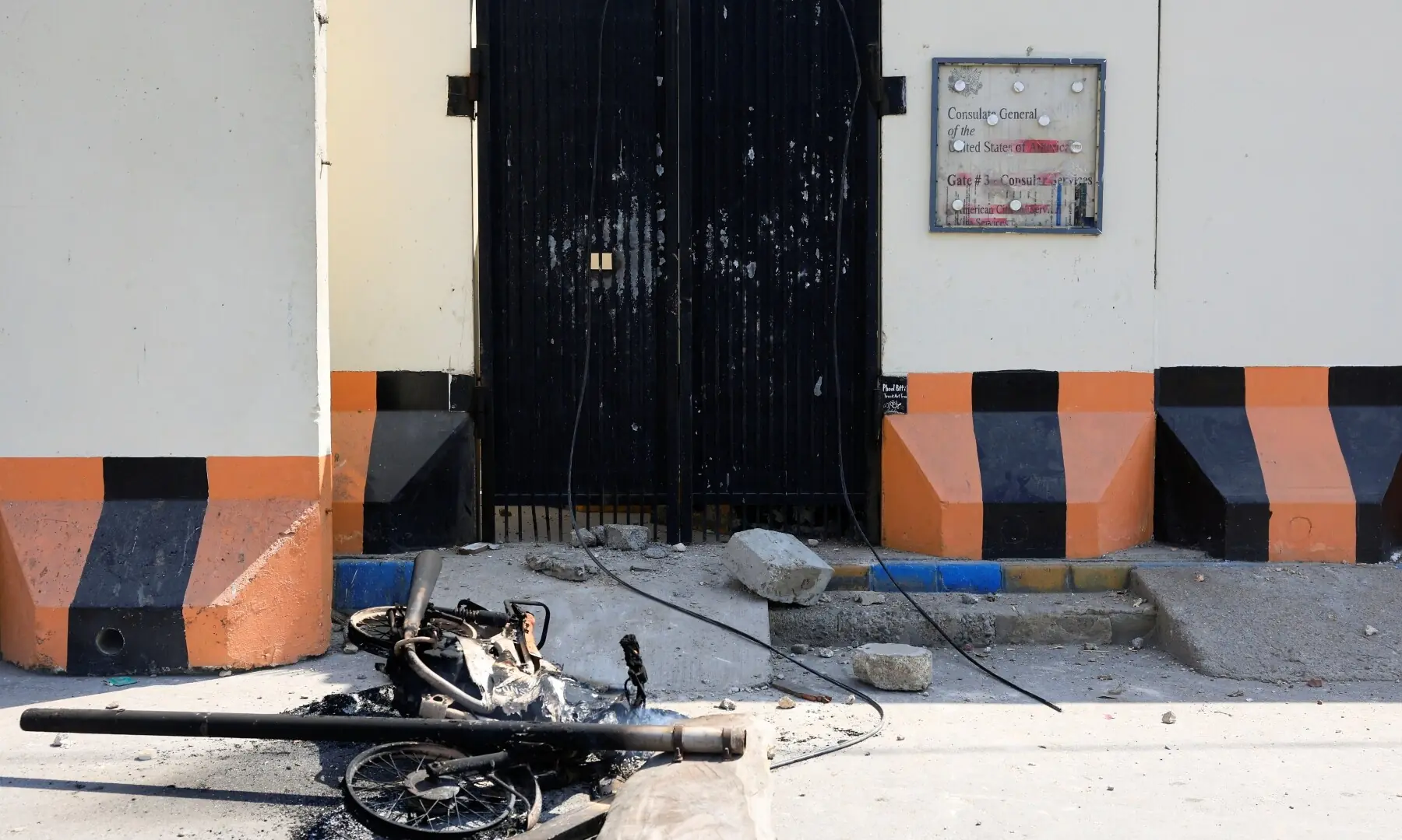 A burnt motorbike lies on the road after it was burned by protesters as they gathered outside the US Consulate General, following news of US and Israeli strikes on Iran that assassinated supreme leader Ayatollah Ali Khamenei, in Karachi on March 1, 2026. &mdash; Reuters
