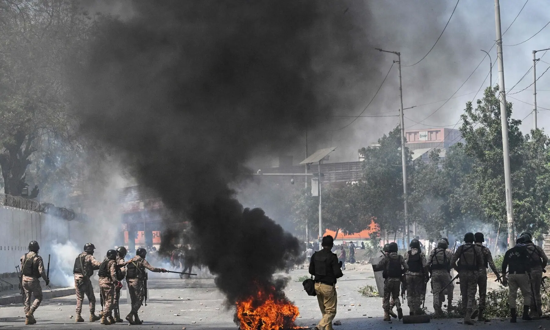 Security personnel fire tear gas as protesters shout slogans during a protest outside the US consulate in Karachi on March 1, 2026. &mdash; AFP