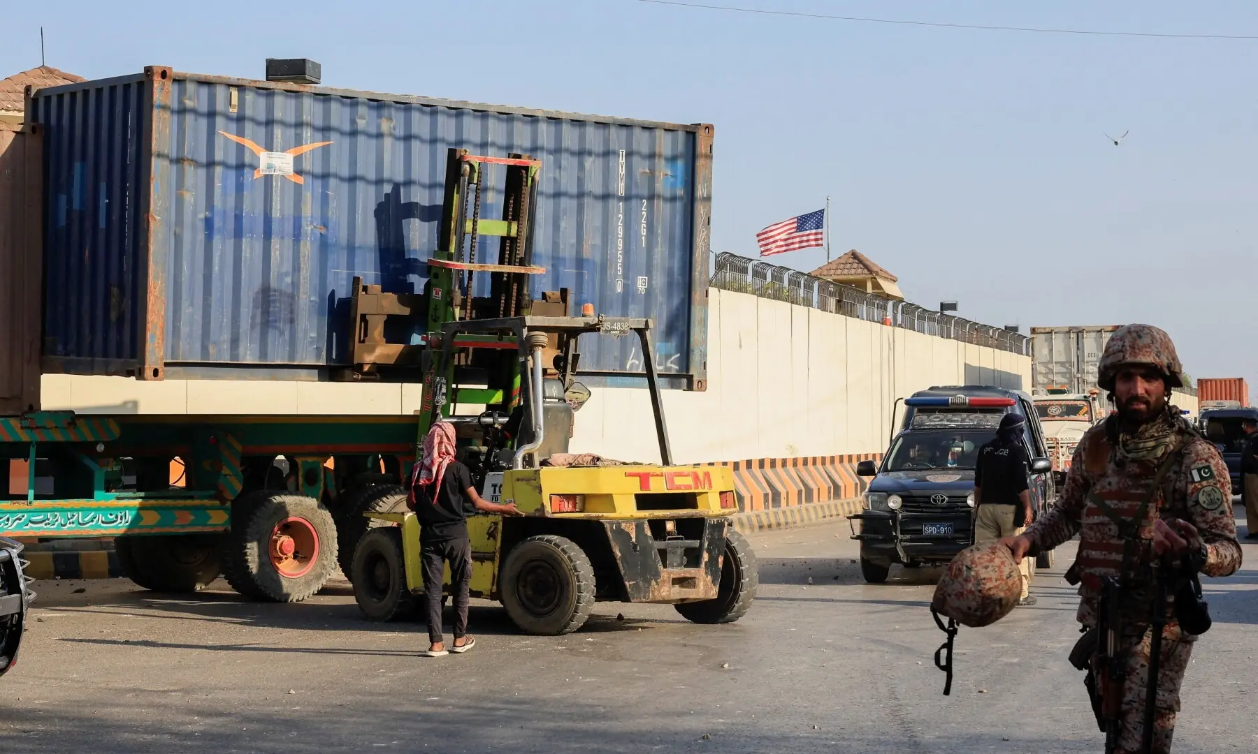 A paramilitary soldier walks past as the shipping container is being placed to block the way during a protest, outside the US Consulate General in Karachi on March 1, 2026. &mdash; Reuters