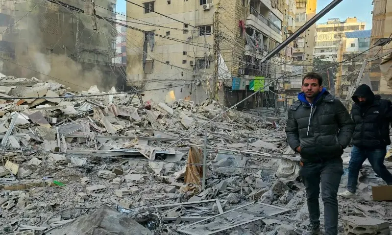 People walk on the rubble of buildings damaged in an early morning Israeli strike on Beirut&rsquo;s southern suburbs on March 3, 2026. &mdash;AFP