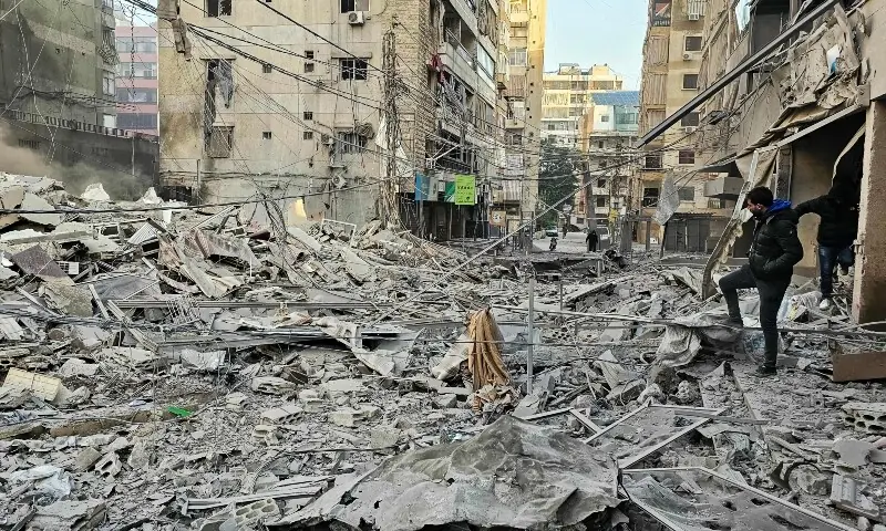 People walk on the rubble of buildings damaged in an early morning Israeli strike on Beirut&rsquo;s southern suburbs on March 3, 2026. &mdash;AFP