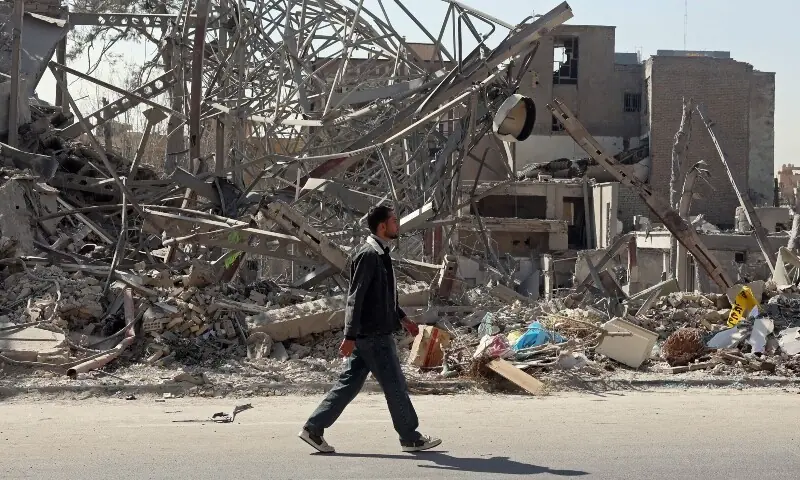 A man walks past destroyed buildings following airstrikes in central Tehran, Iran on March 4.. &mdash; AFP