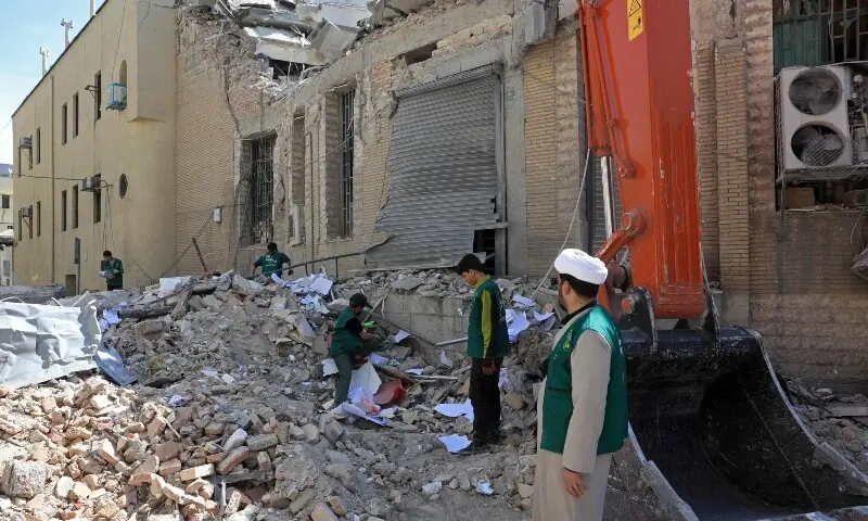 People inspect the debris of a damaged building following airstrikes in central Tehran, Iran on March 4. &mdash; AFP