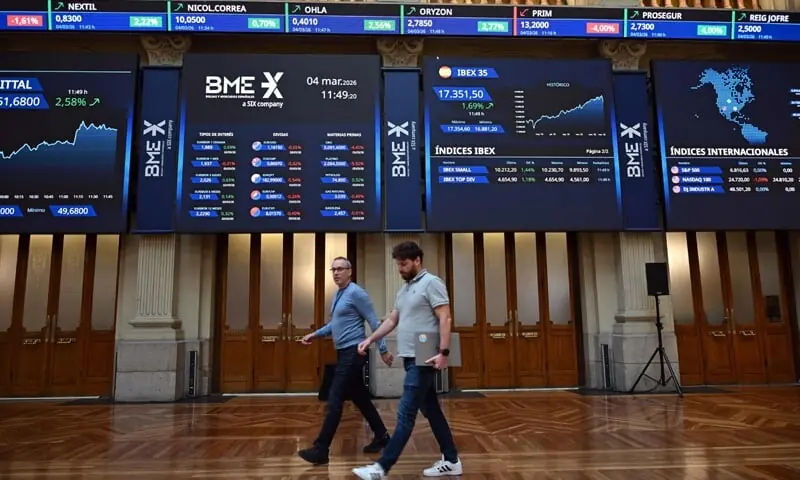 People walk past at the Madrid Stock Exchange. Markets were down sharply across the world following the weekend US-Israel attacks on Iran, with oil prices rising.&mdash;AFP