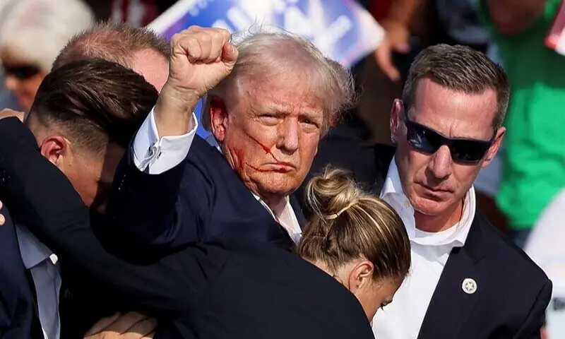 Republican presidential candidate and former US President Donald Trump raises his fist as he is assisted by US Secret Service after he was shot at during a campaign rally at the in Butler, Pennsylvania on July 13. &mdash; Reuters/File