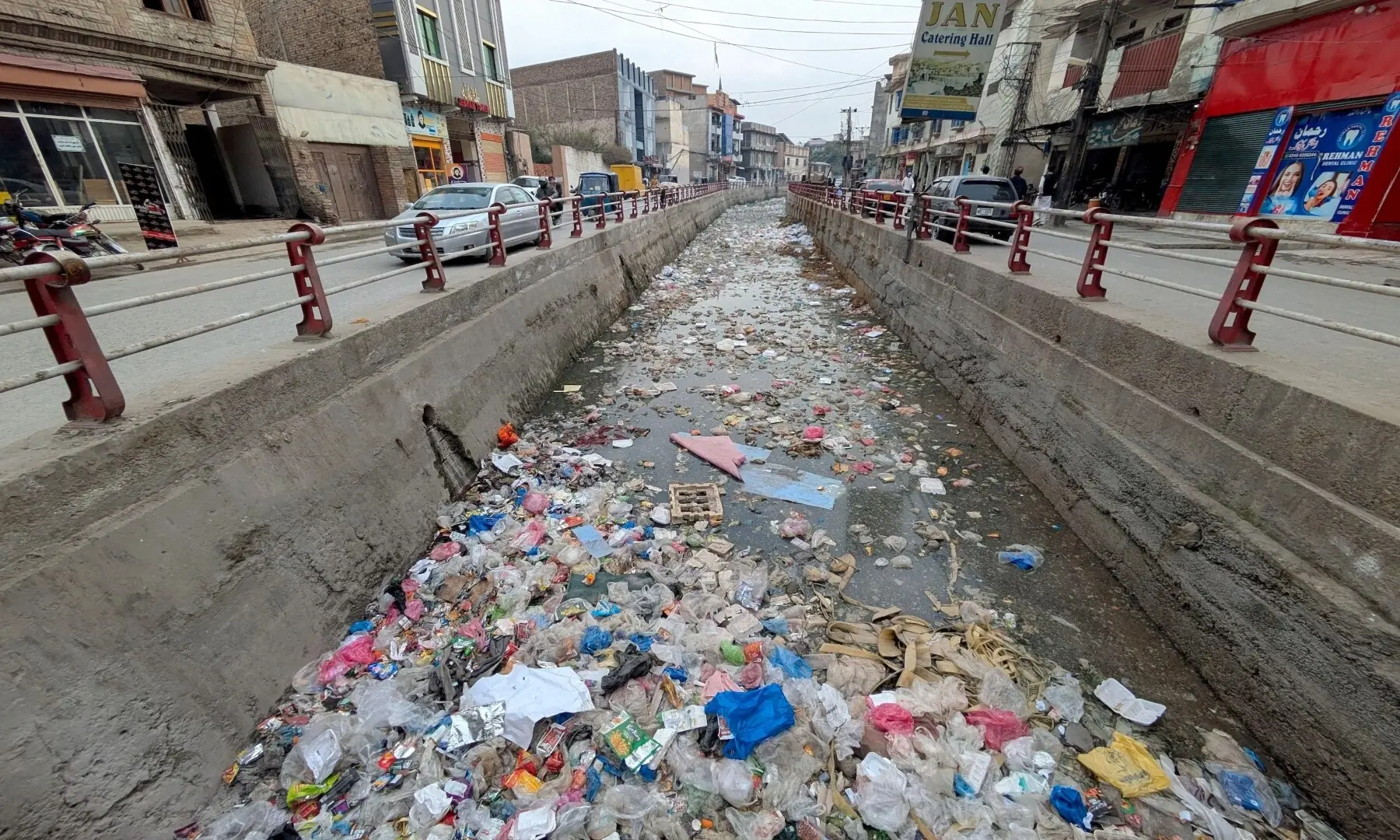 Garbage chokes a canal along Faqirabad Road in Peshawar, Pakistan, blocking water flow and creating foul conditions for nearby residents. &mdash; Hussain Ali / ZUMA Press / Alamy via Dialogue Earth