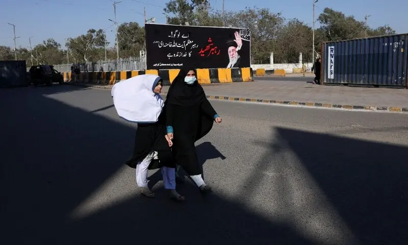 People walk past a banner of Iran&rsquo;s supreme leader Ayatollah Ali Khamenei during a demonstration protesting his assassination in US and Israeli strikes, in Karachi on March 6. &mdash; Reuters