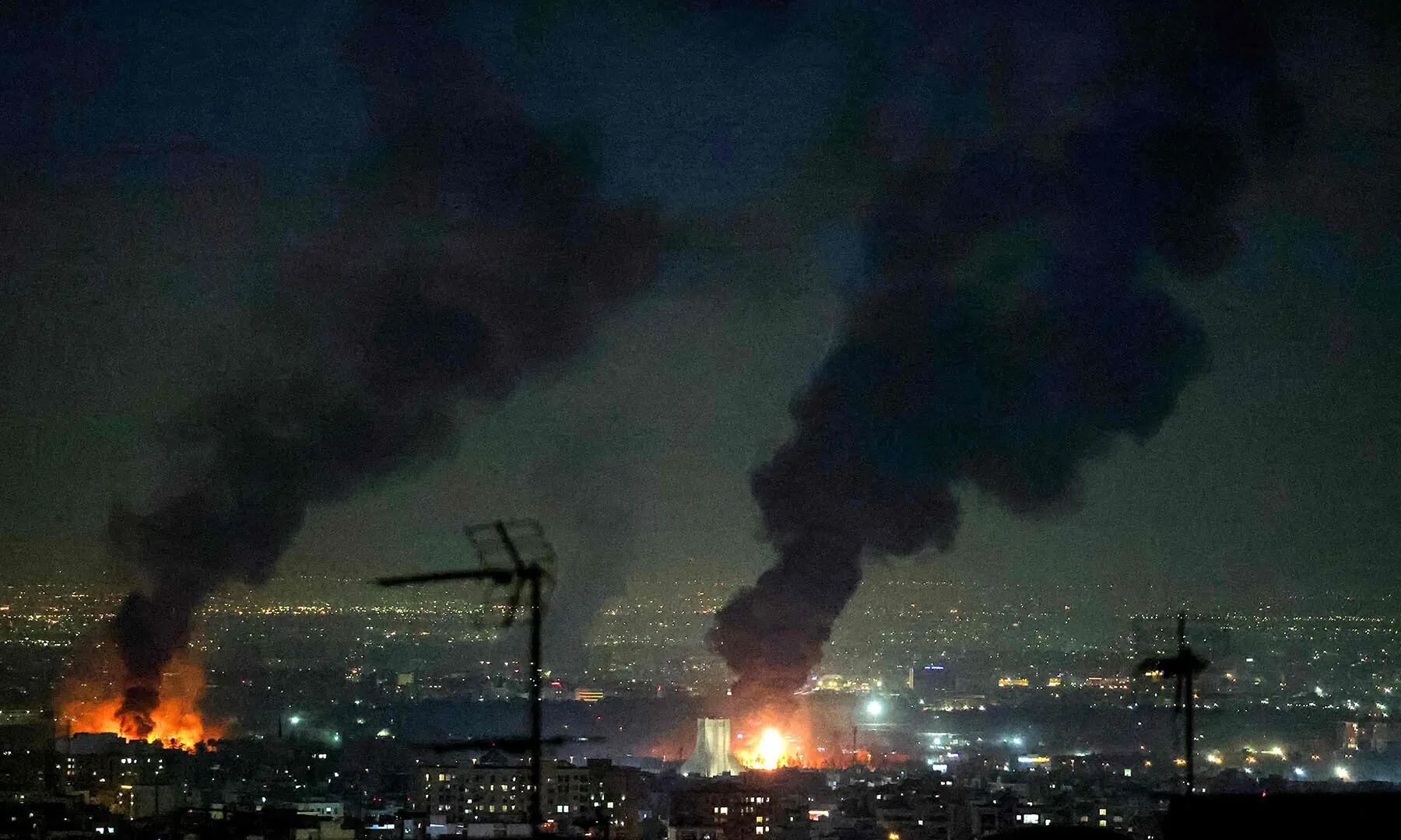 Plumes of black smoke rise following strikes near Azadi Tower, close to Mehrabad International Airport, in Tehran, Iran on March 7. &mdash; AFP