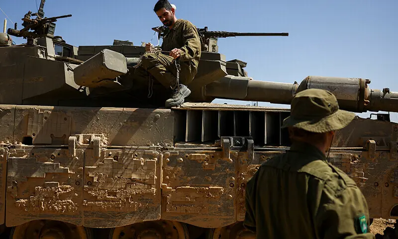 Israeli soldiers conduct some maintenance work on a Merkava tank near the Israel-Gaza border, on April 3, 2024. &mdash; Reuters/File