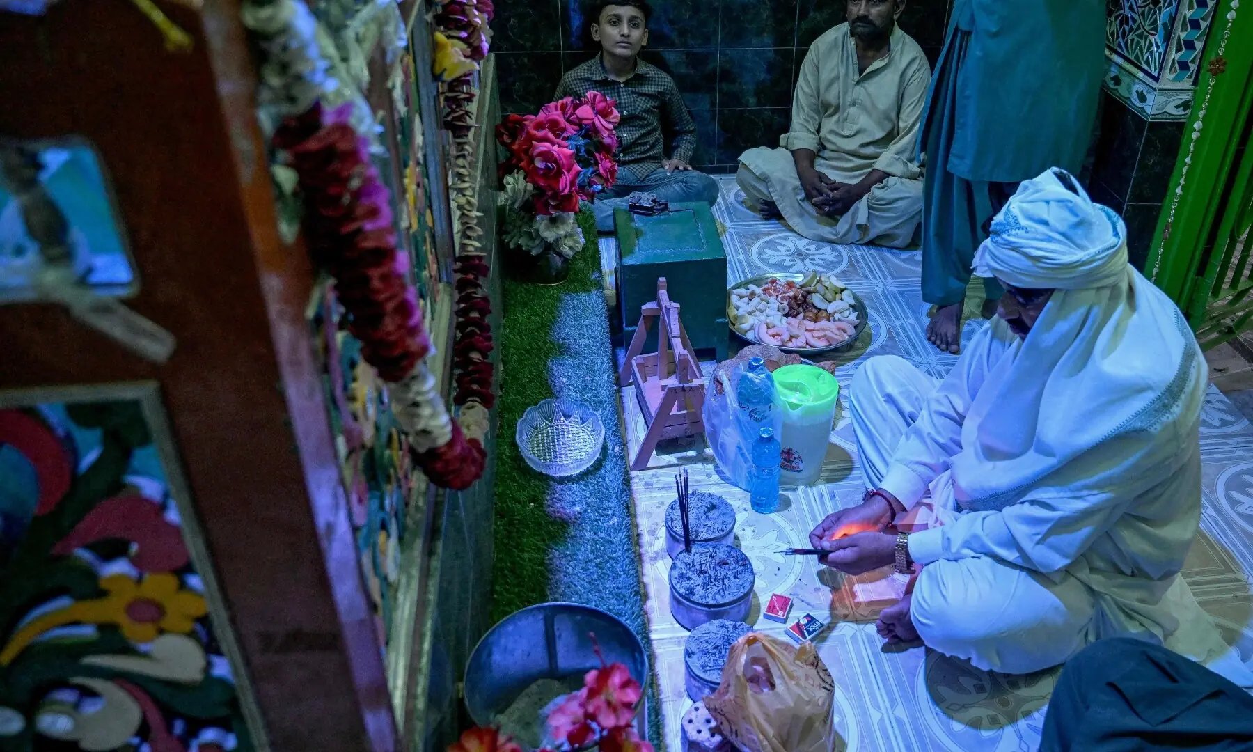 This photograph taken on February 26, 2026 shows Mohan Lal Malhi (R), a Hindu caretaker of a Sufi shrine, praying before breaking his fast during Ramazan at Mithi in the Tharparkar district of Sindh. &mdash; AFP